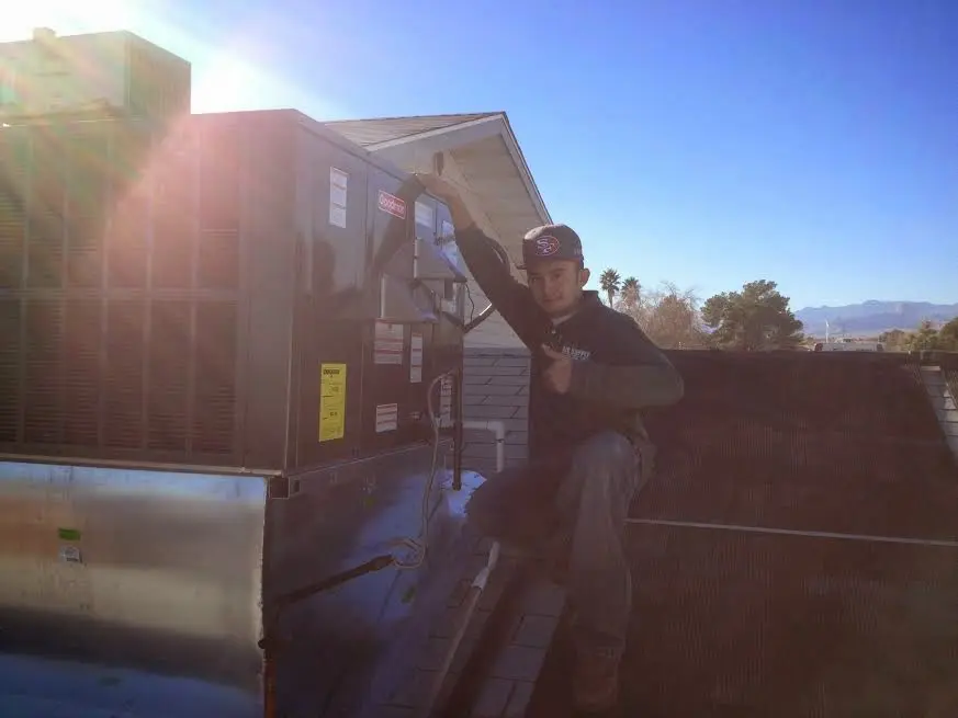 HVAC technician performing Boiler Repair on a rooftop unit in Avra Valley